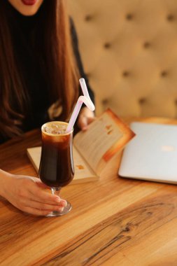 Kitap ya da dergi okurken bir fincan kahve.