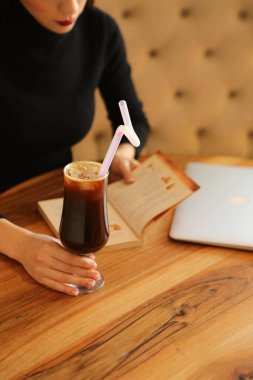 Kitap ya da dergi okurken bir fincan kahve.