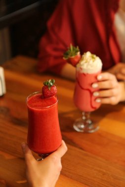 Bir bardak ahududu milkshake, krem şanti ve taze ahududu.