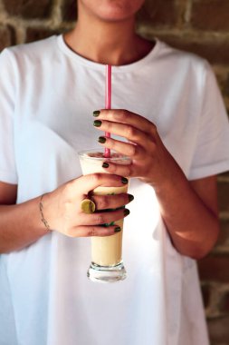 Sütlü buzlu kahve. Buzlu kahve. Elinde bir bardak buzlu kahve tutan kadın..
