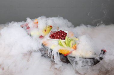 Lezzetli karışık meyveler ve dilimlenmiş meyvelerle dolu bir tabak.