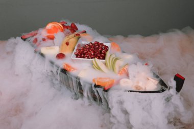 Lezzetli karışık meyveler ve dilimlenmiş meyvelerle dolu bir tabak.