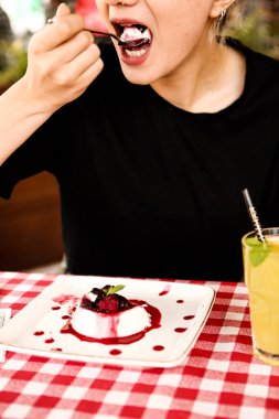 Bir kafede pasta yiyen bir kadının yakın çekimi.