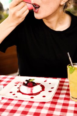 Bir kafede pasta yiyen bir kadının yakın çekimi.