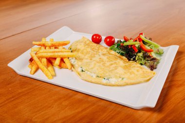 Lezzetli omlet ve kahvaltı tabağı masada..