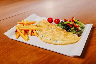 Lezzetli omlet ve kahvaltı tabağı masada..