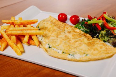 Lezzetli omlet ve kahvaltı tabağı masada..