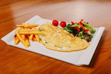 Lezzetli omlet ve kahvaltı tabağı masada..