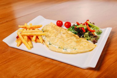 Lezzetli omlet ve kahvaltı tabağı masada..