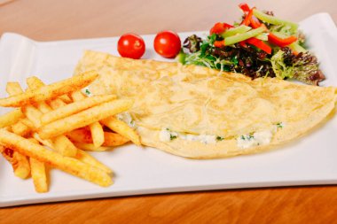 Lezzetli omlet ve kahvaltı tabağı masada..