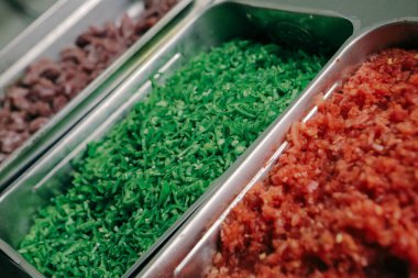 Çelik kaplarda sebze ve et.