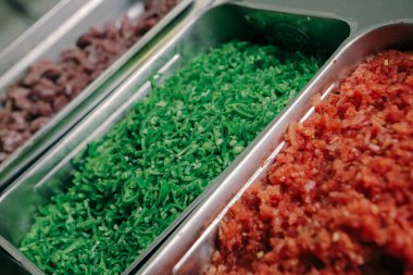 Çelik kaplarda sebze ve et.