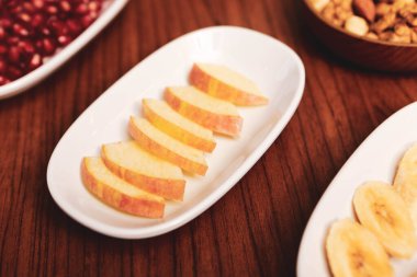 Lezzetli karışık meyveler ve dilimlenmiş meyvelerle dolu bir tabak.