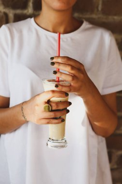 Sütlü buzlu kahve. Buzlu kahve. Elinde bir bardak buzlu kahve tutan kadın..