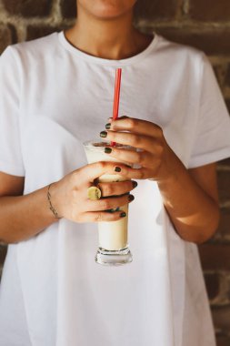 Sütlü buzlu kahve. Buzlu kahve. Elinde bir bardak buzlu kahve tutan kadın..