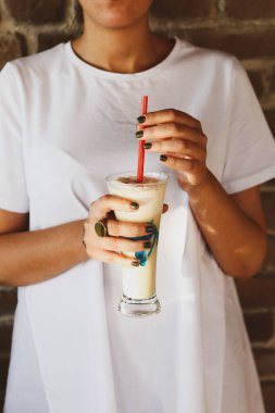 Sütlü buzlu kahve. Buzlu kahve. Elinde bir bardak buzlu kahve tutan kadın..