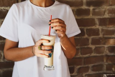 Sütlü buzlu kahve. Buzlu kahve. Elinde bir bardak buzlu kahve tutan kadın..