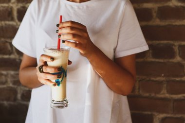 Sütlü buzlu kahve. Buzlu kahve. Elinde bir bardak buzlu kahve tutan kadın..