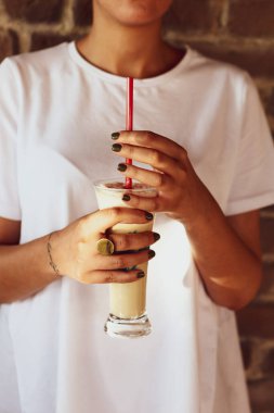 Sütlü buzlu kahve. Buzlu kahve. Elinde bir bardak buzlu kahve tutan kadın..