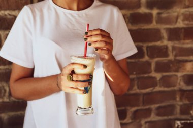 Sütlü buzlu kahve. Buzlu kahve. Elinde bir bardak buzlu kahve tutan kadın..