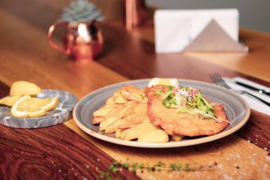 Patates kızartmasıyla servis edilen lezzetli şnitzel.