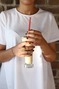 Sütlü buzlu kahve. Buzlu kahve. Elinde bir bardak buzlu kahve tutan kadın..