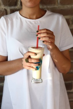 Sütlü buzlu kahve. Buzlu kahve. Elinde bir bardak buzlu kahve tutan kadın..