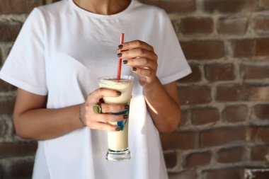 Sütlü buzlu kahve. Buzlu kahve. Elinde bir bardak buzlu kahve tutan kadın..