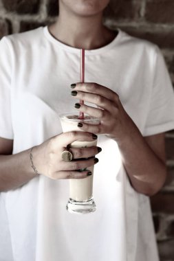 Sütlü buzlu kahve. Buzlu kahve. Elinde bir bardak buzlu kahve tutan kadın..