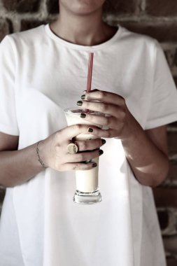 Sütlü buzlu kahve. Buzlu kahve. Elinde bir bardak buzlu kahve tutan kadın..