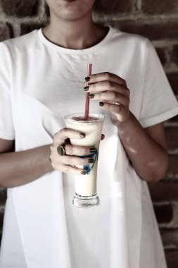 Sütlü buzlu kahve. Buzlu kahve. Elinde bir bardak buzlu kahve tutan kadın..