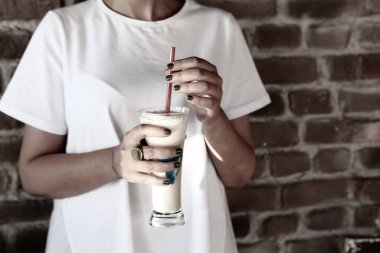 Sütlü buzlu kahve. Buzlu kahve. Elinde bir bardak buzlu kahve tutan kadın..