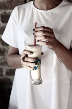 Sütlü buzlu kahve. Buzlu kahve. Elinde bir bardak buzlu kahve tutan kadın..