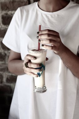 Sütlü buzlu kahve. Buzlu kahve. Elinde bir bardak buzlu kahve tutan kadın..