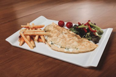 Lezzetli omlet ve kahvaltı tabağı masada..