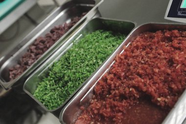 Çelik kaplarda sebze ve et.