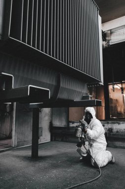 Fabrika, çalışanlar iş yerinde kimyasal koruyucu giysi giyerler. Boya püskürtme.