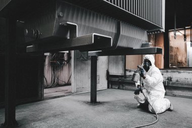 Fabrika, çalışanlar iş yerinde kimyasal koruyucu giysi giyerler. Boya püskürtme.
