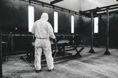 Fabrika, çalışanlar iş yerinde kimyasal koruyucu giysi giyerler. Boya püskürtme.