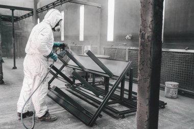 Fabrika, çalışanlar iş yerinde kimyasal koruyucu giysi giyerler. Boya püskürtme.