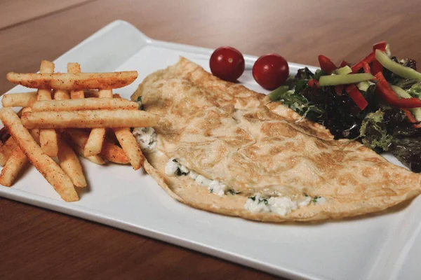 Lezzetli omlet ve kahvaltı tabağı masada..