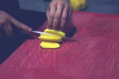 İnsan yemek pişirmek için patatesleri doğrar..
