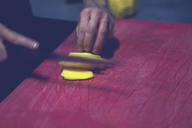 İnsan yemek pişirmek için patatesleri doğrar..
