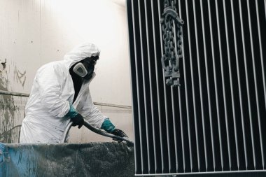 Fabrika, çalışanlar iş yerinde kimyasal koruyucu giysi giyerler. Boya püskürtme.