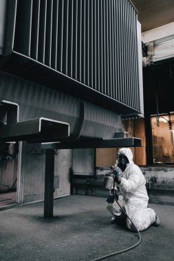 Fabrika, çalışanlar iş yerinde kimyasal koruyucu giysi giyerler. Boya püskürtme.
