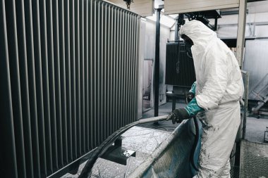 Fabrika, çalışanlar iş yerinde kimyasal koruyucu giysi giyerler. Boya püskürtme.
