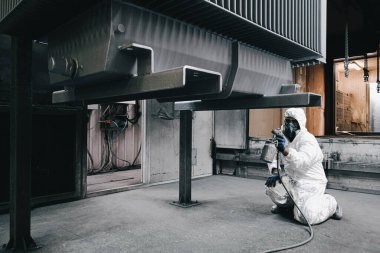 Fabrika, çalışanlar iş yerinde kimyasal koruyucu giysi giyerler. Boya püskürtme.