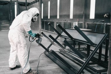 Fabrika, çalışanlar iş yerinde kimyasal koruyucu giysi giyerler. Boya püskürtme.