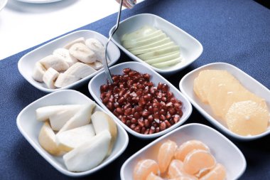 Lezzetli karışık meyveler ve dilimlenmiş meyvelerle dolu bir tabak.