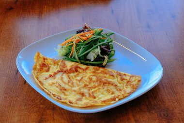 Lezzetli omlet ve kahvaltı tabağı masada..